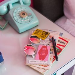 Rambler: view of teal phone, sunglasses, rambler key card and California maps