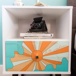 Rambler: view of nightstand with graphic on it and books and camera on it