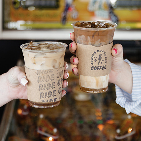 Two hands holding to-go iced coffees