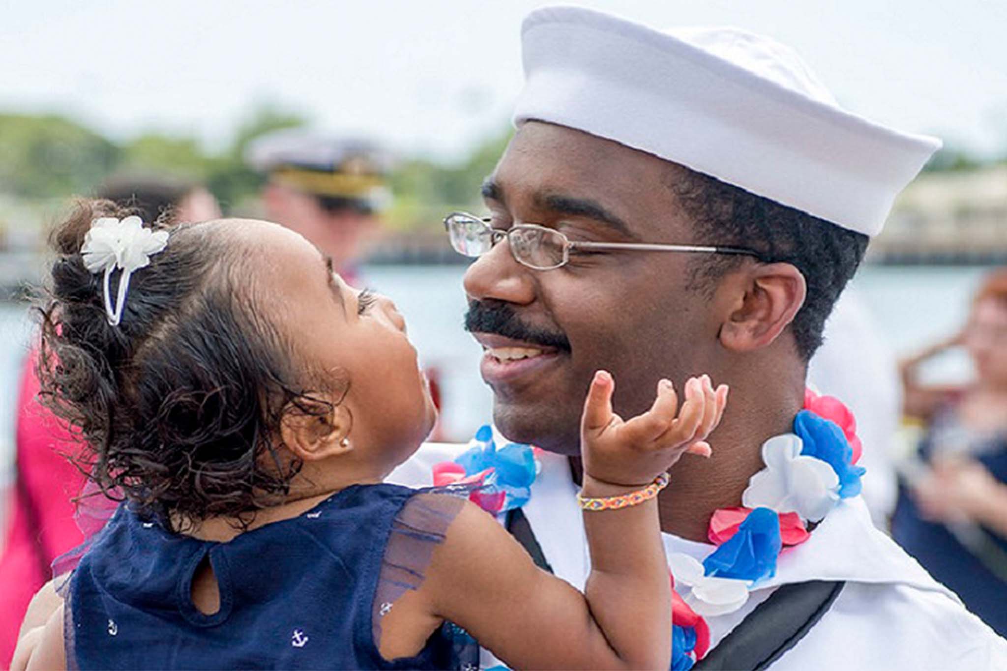 Navy father holding his daughter sweetly looking into each other's eyes