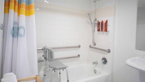 Chair and hand rails in ADA accessible bath tub