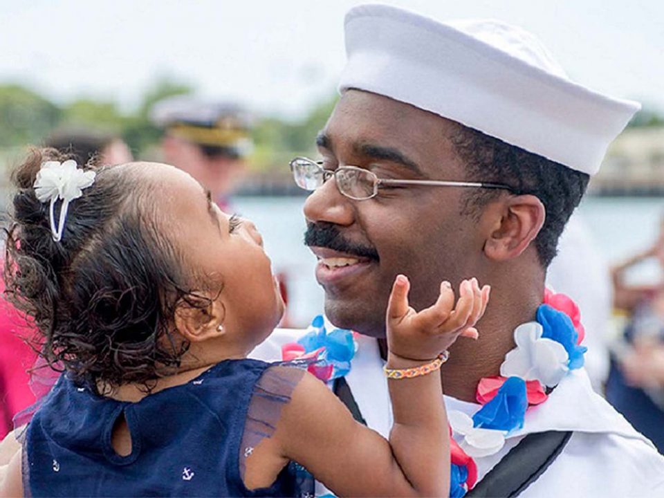 Navy father holding his daughter sweetly looking into each other's eyes