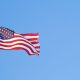 American flag blowing in the wind in a blue sky