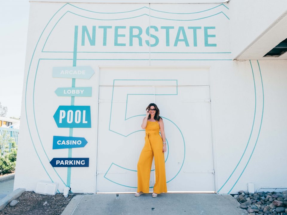 Girl in yellow standing in front of Interstate way-finding sign