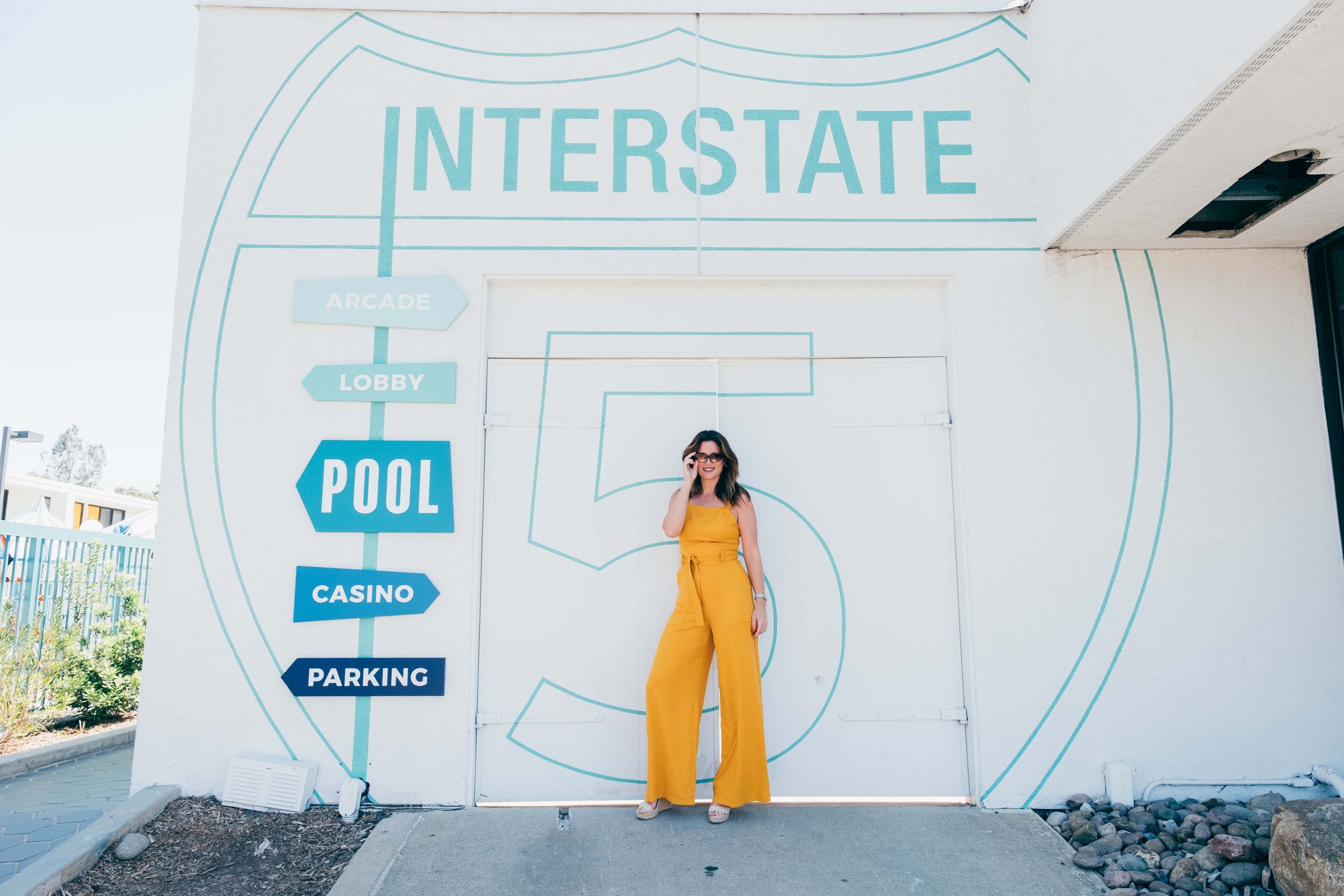 Girl in yellow standing in front of Interstate way-finding sign